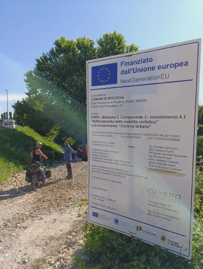 Baustellenschild für eine 'Ciclovia Urbana' mitten im Schotterfeld