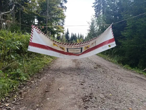Ein Banner des Staatsbetriebs Sachsenforst sperrt den Waldweg